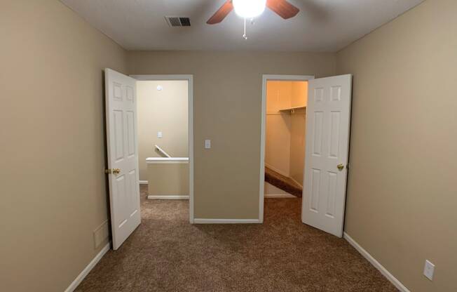 large carpeted bedroom with closet and ceiling fan