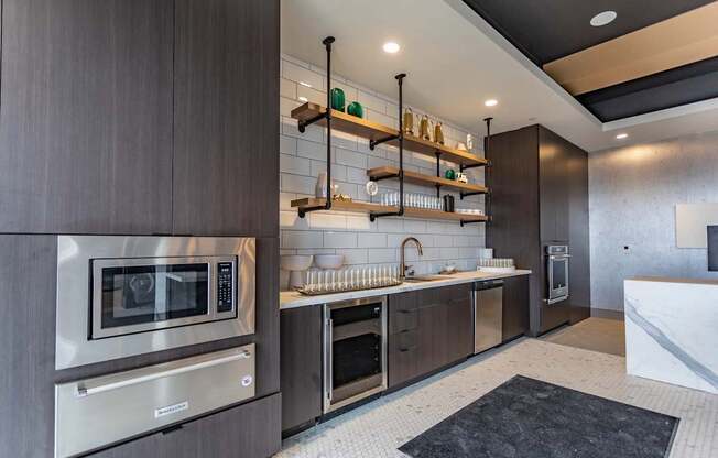 A modern kitchen with dark wood cabinets and stainless steel appliances.