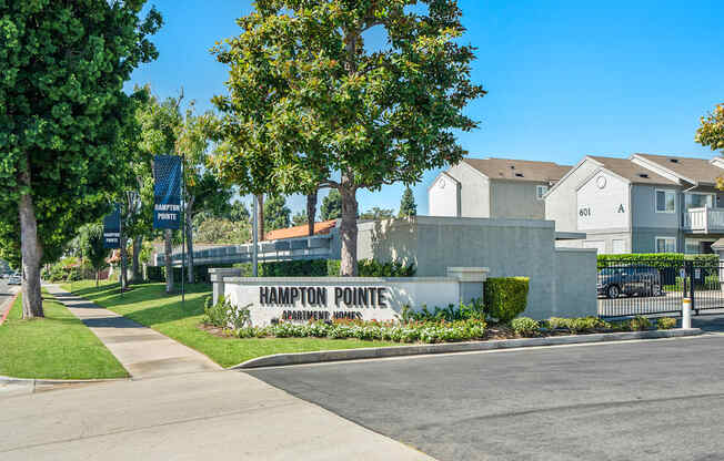 the enclave at harrison pointe apartments sign in front of sidewalk and trees