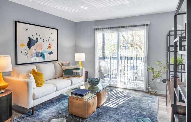 a living room with a couch and a coffee table and a sliding glass door at Station JTown, Louisville, KY, 40299