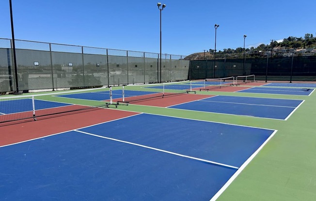 A tennis court with blue and green playing surface and white lines.