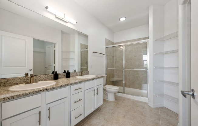a bathroom with white cabinets and a granite countertop