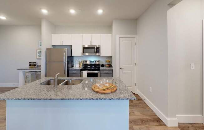 a kitchen with a granite counter top and a stainless steel refrigerator at Echo Park at Perry Crossing Apartments, Indiana, 46168