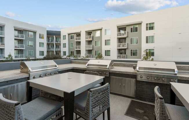 A patio with a table and chairs overlooking apartment buildings.