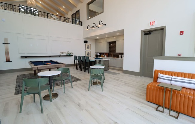 a seating area with tables and chairs and a pool table in the center of the room at The Crest at Acworth, Acworth, GA