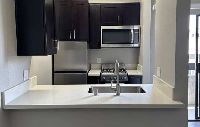 a kitchen with a sink and a stove and a microwave