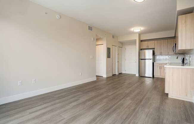 a kitchen and living room with wood flooring and a refrigerator