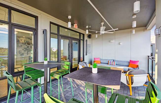 a patio with tables and chairs and sliding glass doors at Link Apartments® Calyx, Chapel Hill, NC 27517