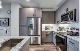 an open kitchen with granite counter tops and stainless steel appliances
