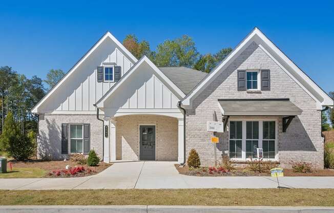 a brick house with a sidewalk in front of it