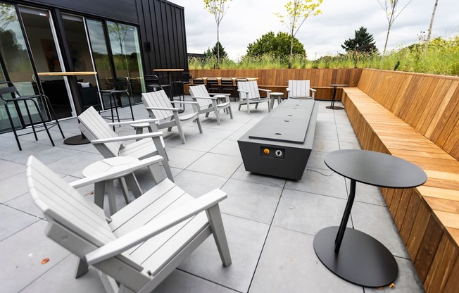 a patio with chairs and tables and a fire pit