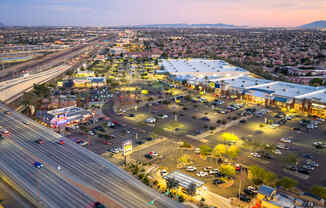 A busy highway interchange with a parking lot and buildings in the foreground.
