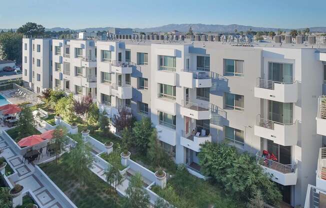 Apartment complex with white buildings and balconies at Woodley Sara Apartment, California