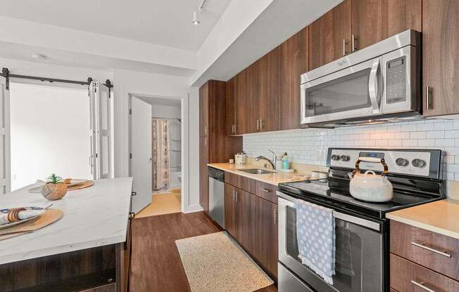 A modern kitchen with dark wood cabinets and a black stove top.