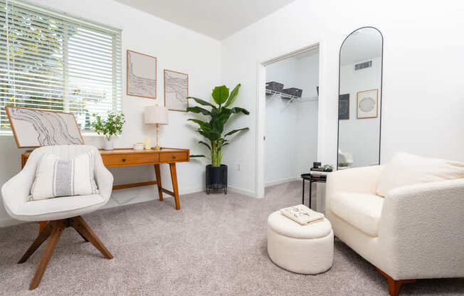 A living room with a chair, a couch, a table, and a plant.