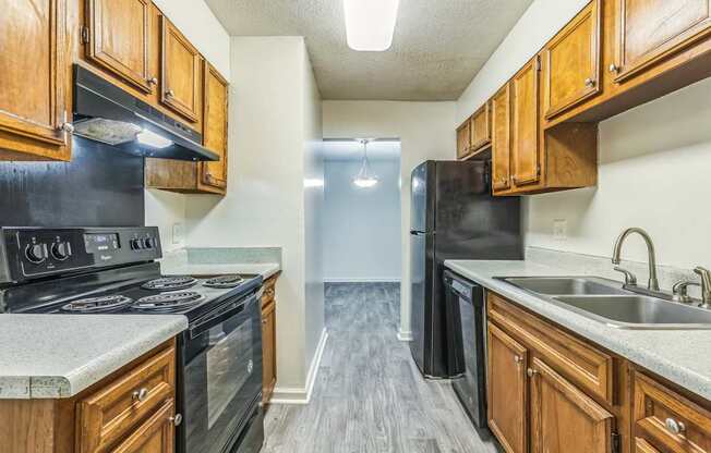A kitchen with black appliances and wooden cabinets.