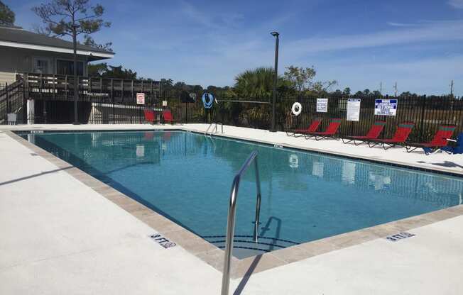 Swimming pool with red chairs around iit at River Crossing Apartments, Thunderbolt, GA, 31404