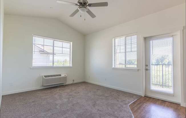 A room with a ceiling fan and two windows at Riverplace Apartment Homes, Independence