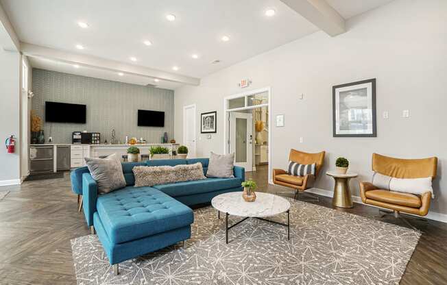 a living room with a blue couch and two chairs