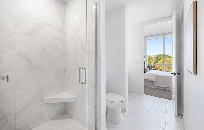 A white bathroom with a walk-in shower and a toilet.