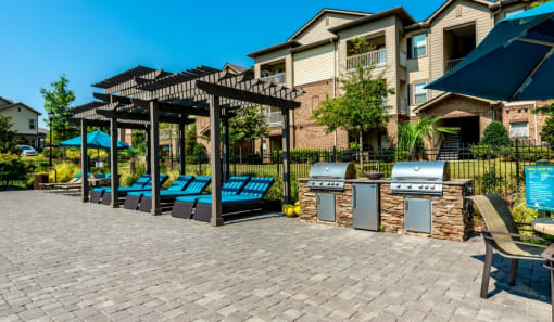 a brick patio with lounge chairs and barbecue grills at Echo at Lake Norman, Mooresville, NC