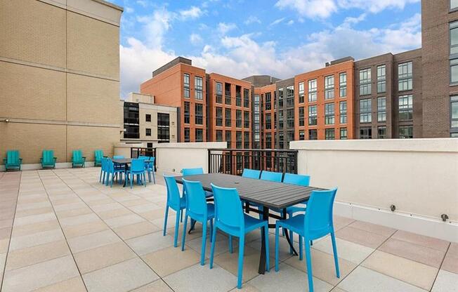 a patio with a table and chairs on top of a building