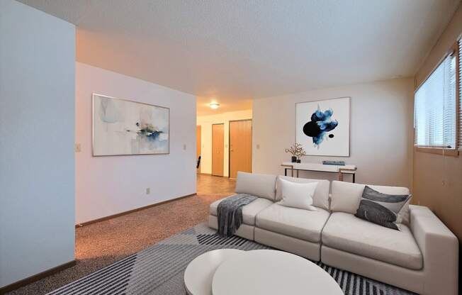 a living room with a white couch and a gray and white rug. Fargo, ND Kennedy Apartments