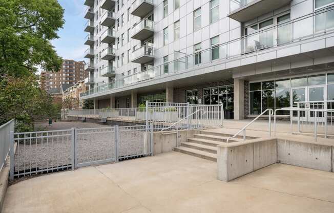 the entrance to an apartment building with stairs and a ramp