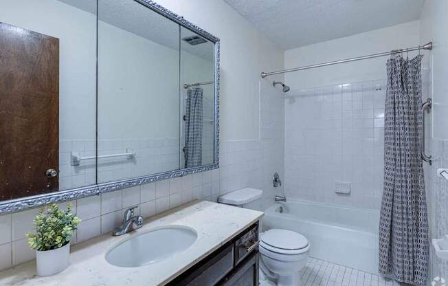 A bathroom with a white sink, toilet, and bathtub.