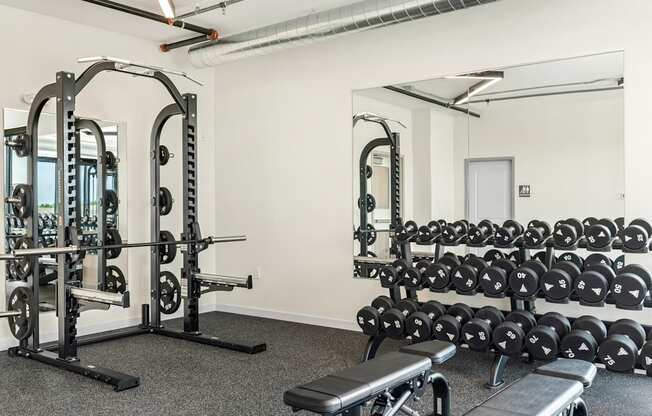 a fitness room with weights machines and mirrors at The Standard on 32nd, North Dakota, 58078