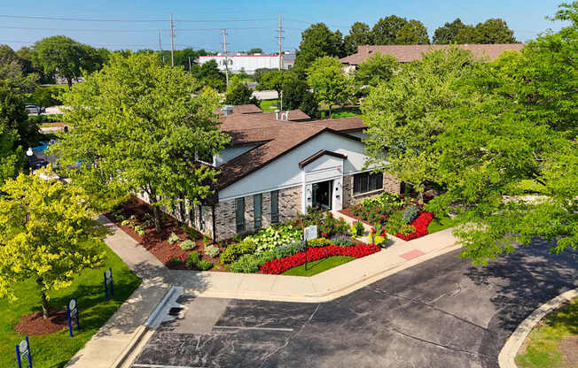 A house with a driveway and trees in front of it.