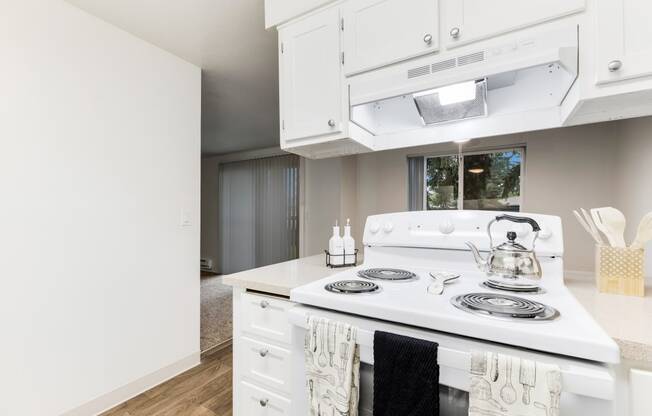 a kitchen with white appliances and white cabinets and a white stove top oven