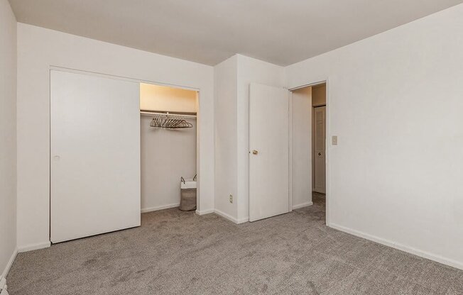 an empty bedroom with white walls and a closet