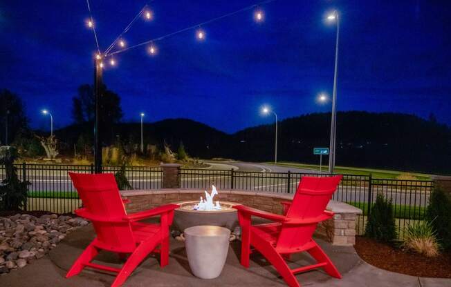 two red chairs around a fire pit on a patio at nightat Scouter's Mountain, Happy Valley, 97086