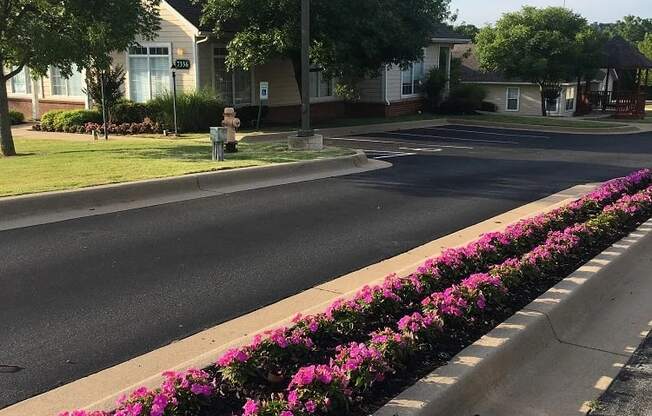 a city street with pink flowers on the side of the road at EDGEWOOD AT GABLES Apartments, TULSA, Oklahoma