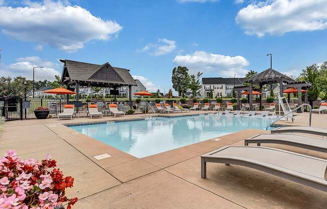 our resort style pool is filled with lounge chairs and umbrellas