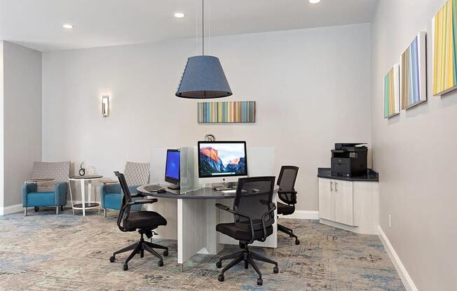 a room with a desk with two computers on it