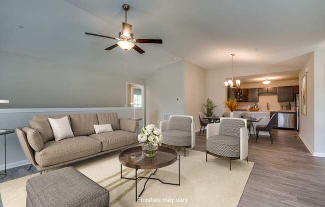 a living room with couches and chairs and a ceiling fan