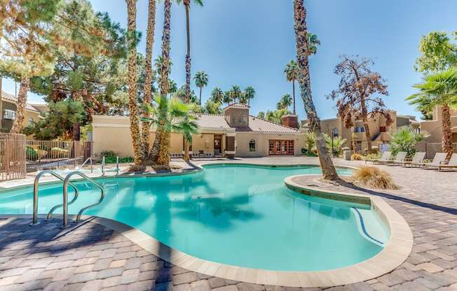 a swimming pool with palm trees and a house in the background at Pacific Harbors Sunrise Apartments, Las Vegas, NV, 89142