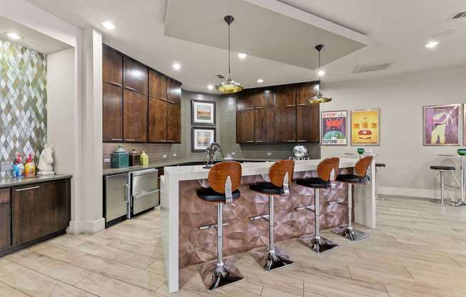 A kitchen with a bar area and chairs.