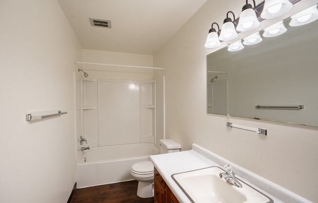 a bathroom with a sink and a toilet and a shower. Fargo, ND Crown Court 1 Apartments