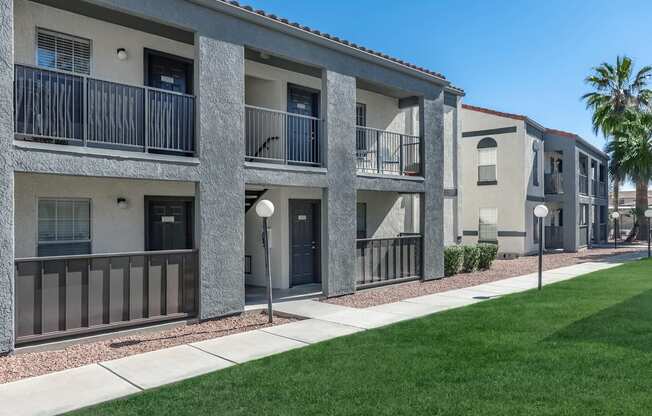 A row of modern apartment buildings with balconies and doors.