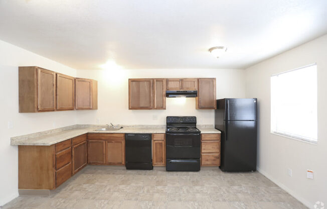 A kitchen with black appliances and wooden cabinets.