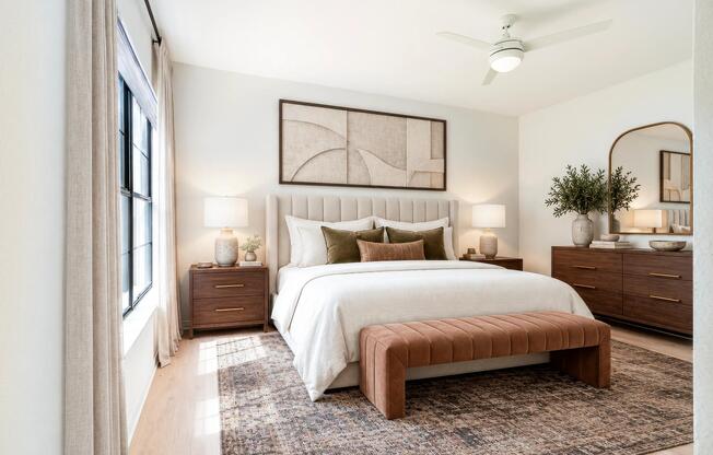 The light finish interior package extends into the primary bedroom with bright, modern finishes, oversized windows, wood-style flooring, and a spacious layout designed for comfort and relaxation.