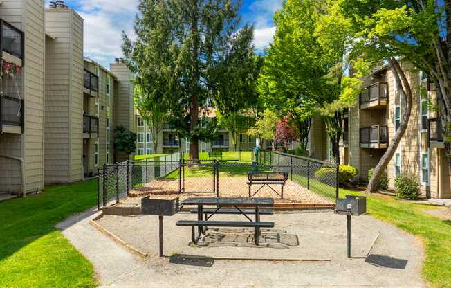 A picnic table is in the middle of a playground in a residential area.