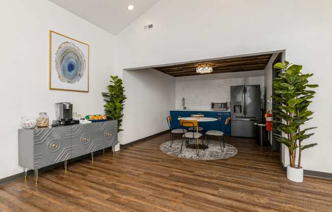 a living room with a blue and white kitchen and a table and chairs