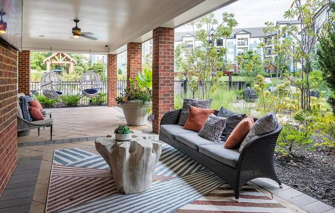 a covered patio with furniture and hammocks