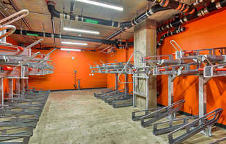 A room with orange walls and a concrete floor with a lot of pipes and metal structures.