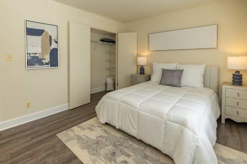 A bedroom with a large bed, two nightstands, and a rug.