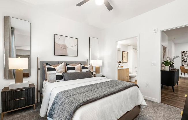 A bedroom with a large bed and a ceiling fan.